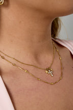 Ketting met kruis- en sterbedeltjes - goud - gedragen om de hals van een model