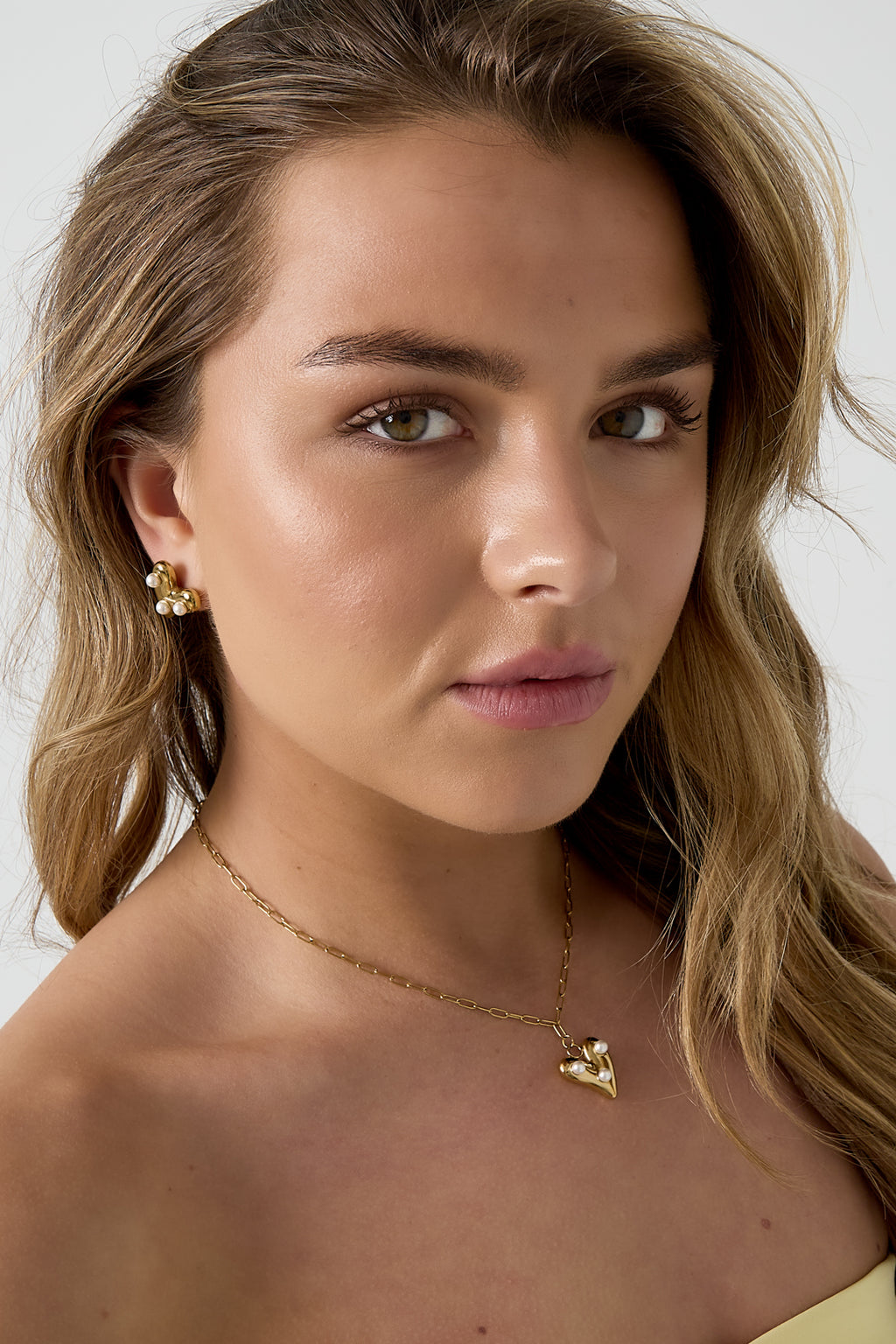Ketting met hangend hartje en parels - gedragen om de hals van een model