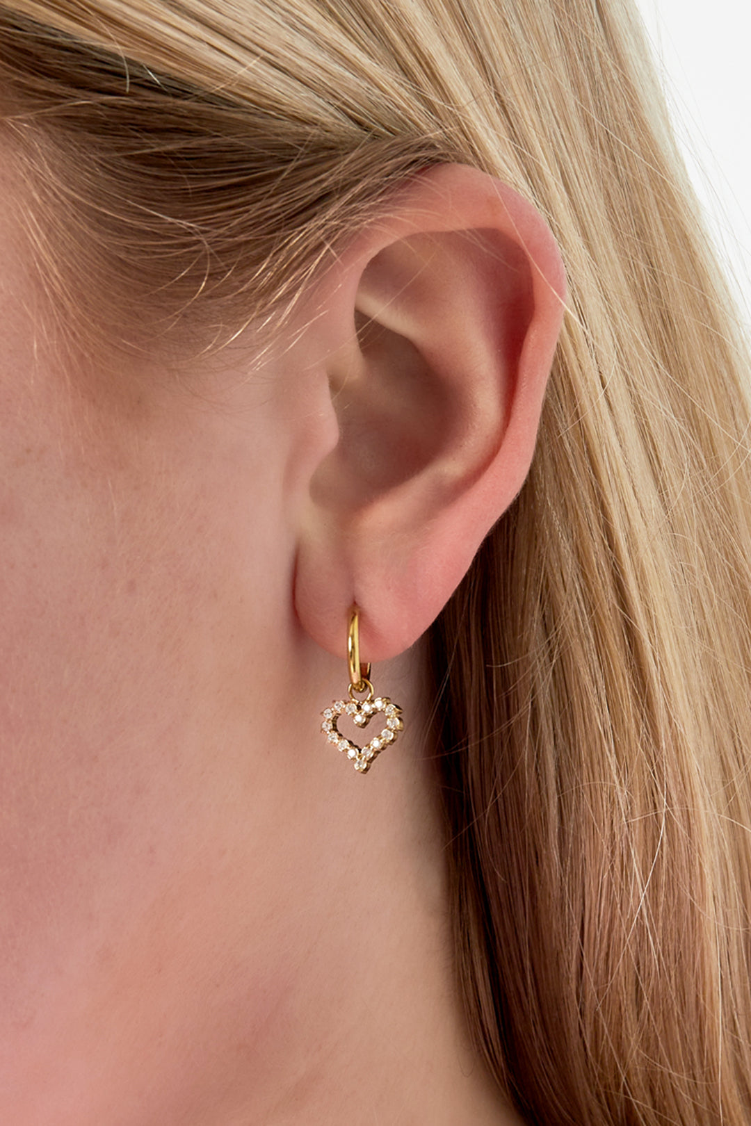 Oorbellen met strass-hartje - goud - gedragen in het oor van een model