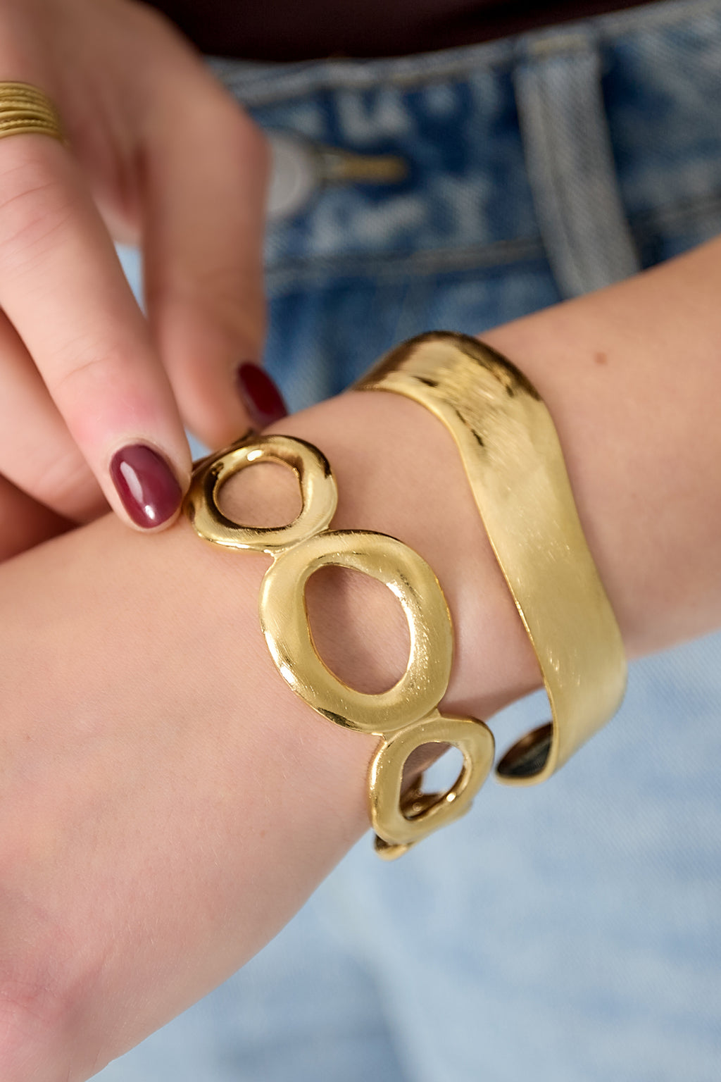 Dikke armband met organische cirkels - goud - gedragen om de arm van een model