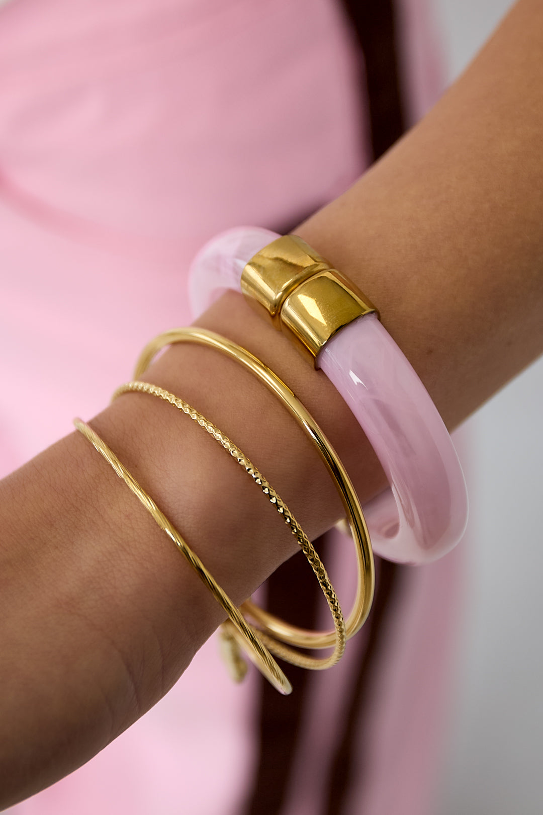 Chunky bangle with gold details - licht roze - gedragen om de arm van een model