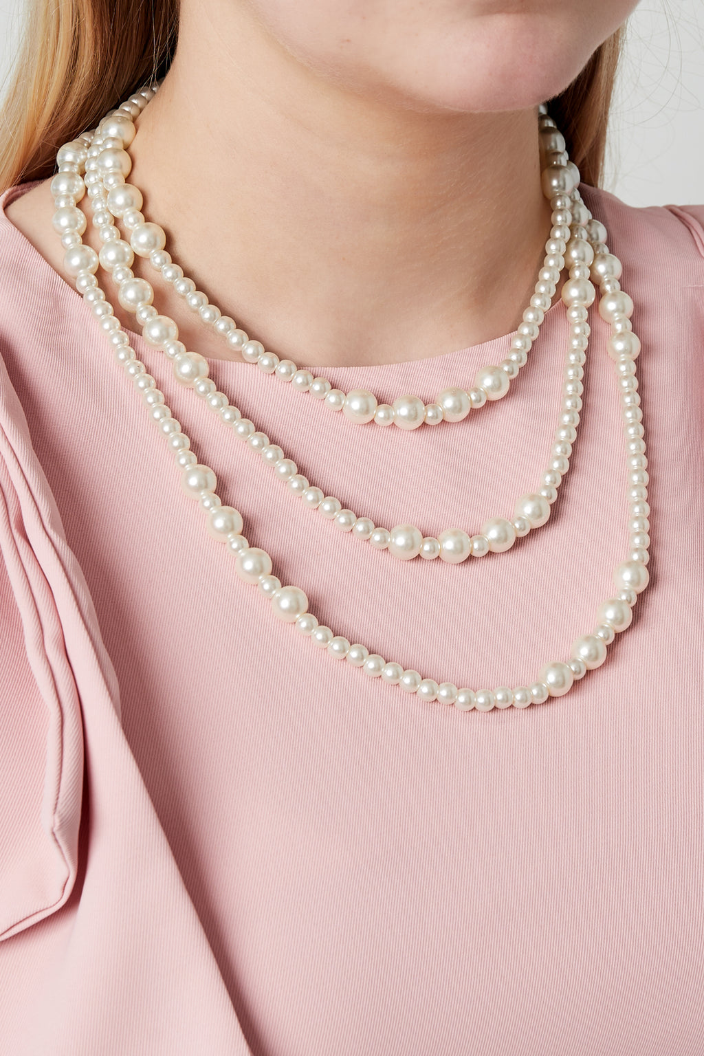 Kleine parels gelaagde ketting - gedragen om de hals van een model