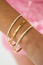 Armband met rij steentjes - goud - gedragen om de arm van een model